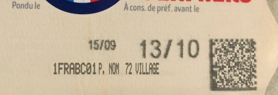 Zone imprimée d'une boîte : pondu le 15/09, à consommer de préférence avant le 13/10, puis 1FRABC01 P. NOM 72 VILLAGE.